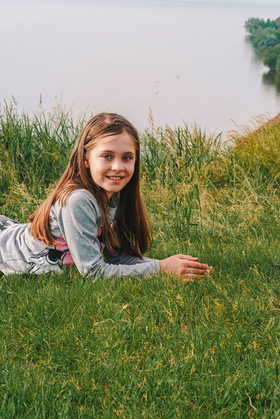 Щаслива маленька дівчинка дитина лежить на зеленій траві
 - Фото, зображення