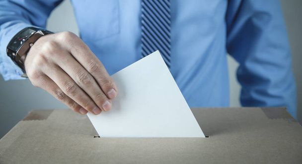 Un homme qui met son bulletin de vote dans les urnes. Démocratie. Liberté - Photo, image