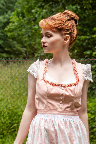 Traditional costume worn by a young model with reddish plug-in hairstyle - Zdjęcie, obraz