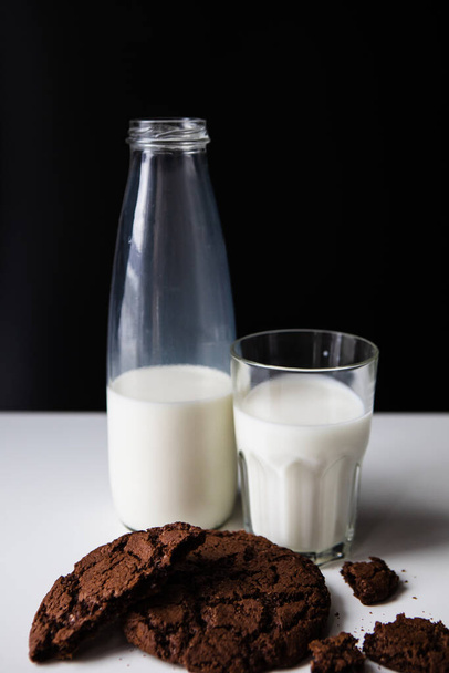 versando il latte nel bicchiere con biscotti al cioccolato. copia spazio - Foto, immagini