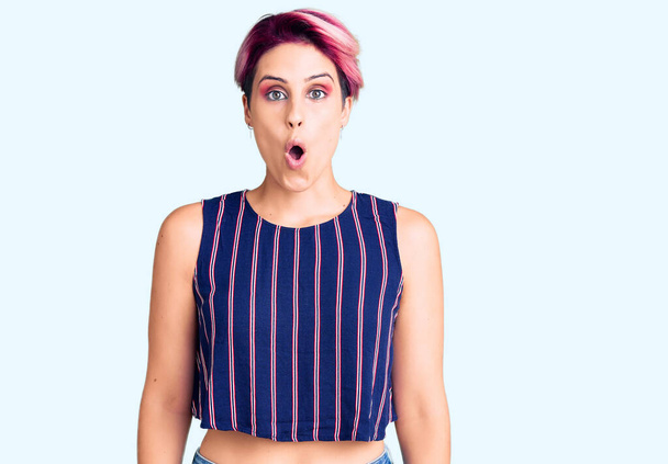 Young beautiful woman with pink hair wearing casual clothes afraid and shocked with surprise expression, fear and excited face.  - Photo, Image