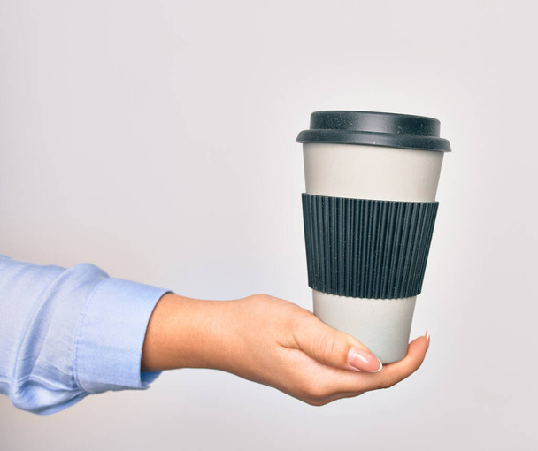 Mão de caucasiano jovem segurando xícara de café takeaway sobre fundo branco isolado - Foto, Imagem