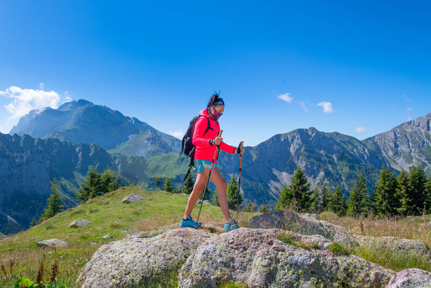 Una mujer camina en las montañas con máscara antivirus
 - Foto, imagen
