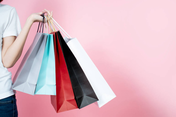 Happy women carrying summer shopping bags isolated on pink background. - Φωτογραφία, εικόνα