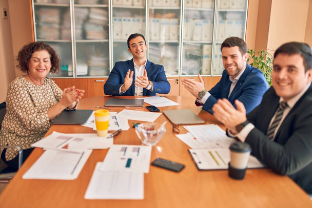 Werknemers van bedrijfsjuristen vergaderen op kantoor van een advocatenkantoor. Professionele uitvoerende partners die werken aan financiën gestrategry op de werkplek. Klappen tegen elkaar voor een succesvolle prestatie. - Foto, afbeelding