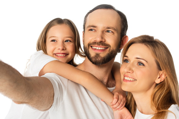Ευτυχισμένη οικογένεια με λευκά μπλουζάκια που αγκαλιάζονται απομονωμένη σε λευκό - Φωτογραφία, εικόνα
