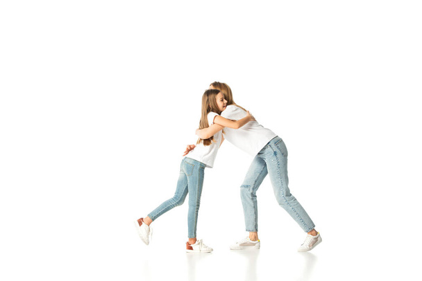 Ευτυχισμένη κόρη αγκαλιάζει μητέρα απομονωμένη στα λευκά - Φωτογραφία, εικόνα