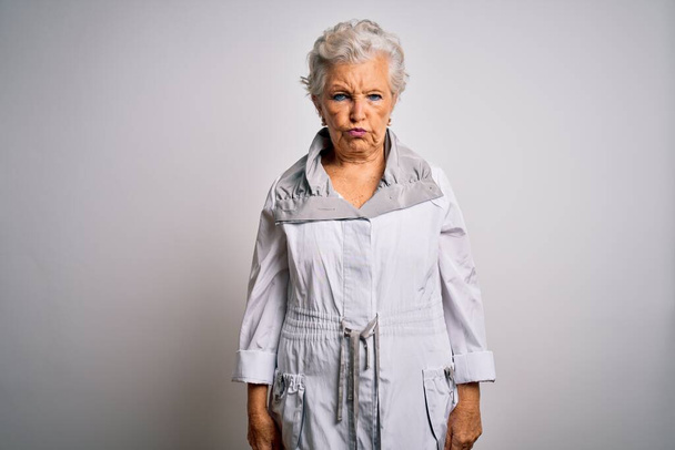 Senior beautiful grey-haired woman wearing casual jacket standing over white background depressed and worry for distress, crying angry and afraid. Sad expression. - Fotó, kép