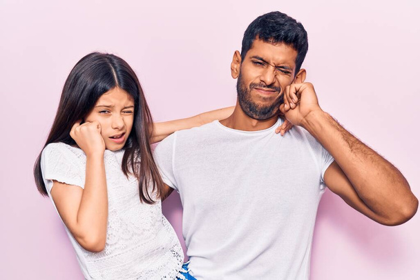 Young father and daughter wearing casual clothes covering ears with fingers with annoyed expression for the noise of loud music. deaf concept.  - Foto, Bild