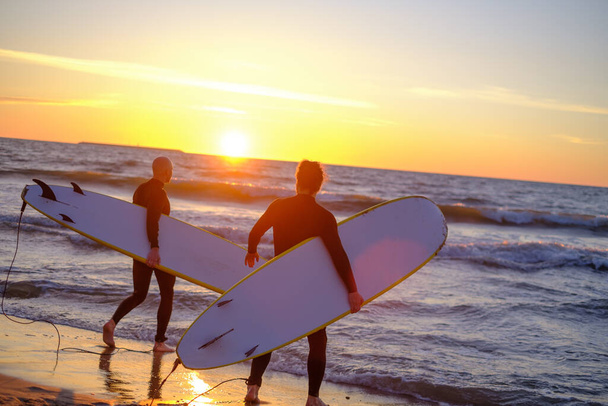 Surfisti irriconoscibili che entrano in mare ondulato - Foto, immagini