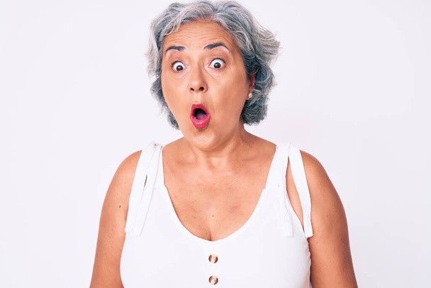 Senior hispánská žena na sobě ležérní oblečení vyděšený a ohromený s otevřenou pusou pro překvapení, nevěřící tvář  - Fotografie, Obrázek