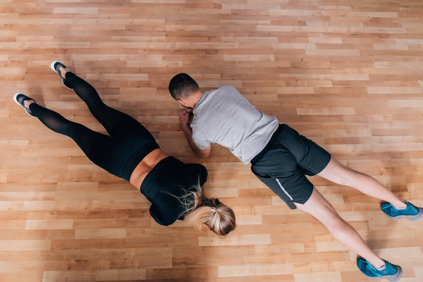Couple or trainer teach or exercise in fitness gym with plank action. Flat lay or upper view with copy space for text. High resulotion image. - Photo, Image