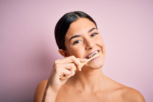 Fiatal gyönyörű barna nő fogmosás fogkefével és szájkrém, tisztító fogak és a nyelv, mint az egészséges egészségügyi reggeli rutin - Fotó, kép