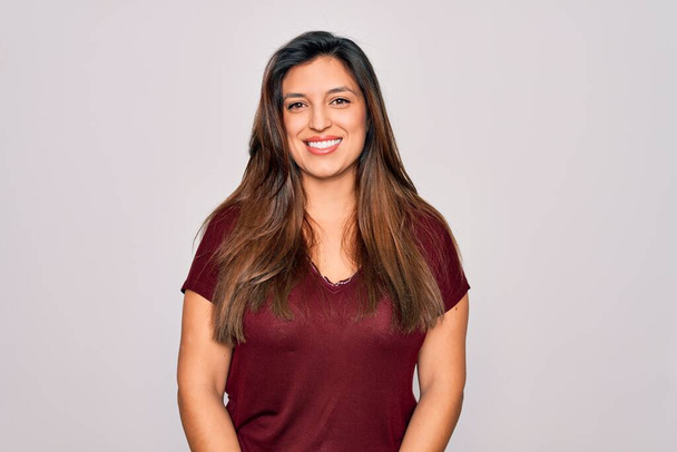 Young hispanic woman wearing casual t-shirt standing over isolated background with a happy and cool smile on face. Lucky person. - Foto, Imagem