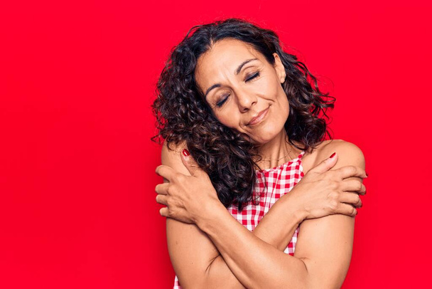 Middle age beautiful woman wearing casual sleeveless t shirt hugging oneself happy and positive, smiling confident. self love and self care  - Photo, Image