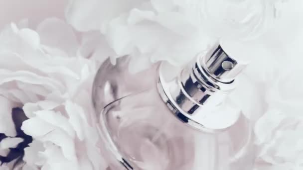 Şakayık çiçekli beyaz parfüm şişesi lüks kozmetik, moda ve güzellik ürünleri arka planında şık bir koku. - Video, Çekim