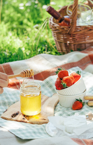 軽食付きの夏のピクニック-チーズ、イチゴ、蜂蜜 - 写真・画像