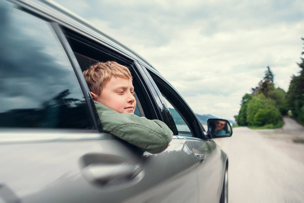 Viaggiare in auto - figlio e padre guardano fuori dai finestrini dell'auto - Foto, immagini