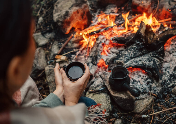Woman drink a coffee near campfire - Zdjęcie, obraz