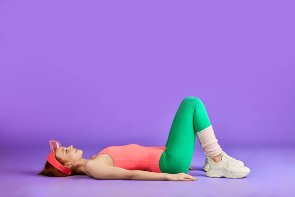 athletic fitness woman lying on the floor, both legs are knees bent - Photo, image