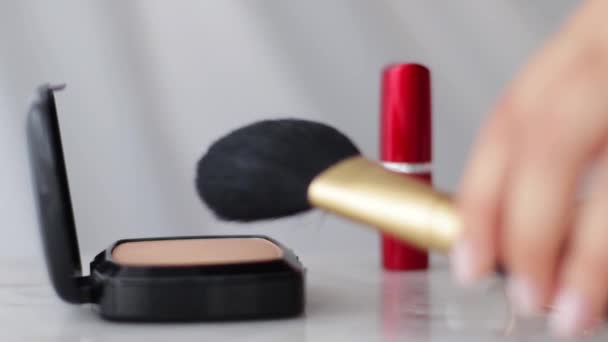 Productos de maquillaje sobre mesa de mármol, polvo, lápiz labial y pincel como fondo para la marca cosmética y de belleza - Imágenes, Vídeo