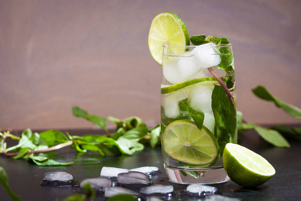 Summer coctail mojito with ice, mint, lime on a grey background. Copy space. - Photo, Image