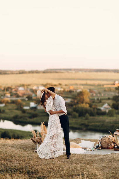 Beautiful wedding couple in nature in boho style. Wedding in the European style of fineart at sunset. - Φωτογραφία, εικόνα