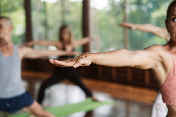 Gruppe von Menschen, die Yoga im Unterricht praktizieren. - Foto, Bild