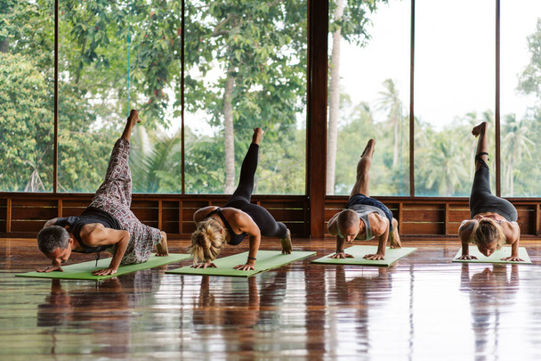 Eine Gruppe von Teilnehmern eines Yoga-Kurses in tropischer Umgebung eines Yoga-Meditations-Retreats - Foto, Bild