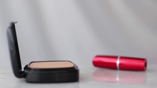 Productos de maquillaje sobre mesa de mármol, polvo, lápiz labial y pincel como fondo para la marca cosmética y de belleza - Metraje, vídeo