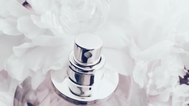 Frasco de perfume blanco con flores de peonía, aroma de fragancia elegante como cosmético de lujo, fondo de productos de moda y belleza - Imágenes, Vídeo