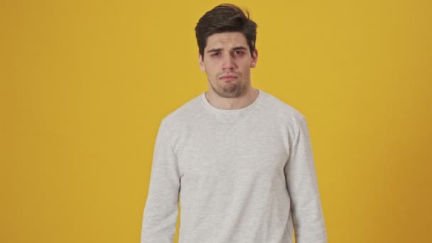 Unhappy sick man having cough and covering his mouth over yellow background - Felvétel, videó