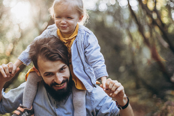 young, stylish bearded father walking with his little daughter in nature at sunset. Family photos of father and one child. selective focus, noise effect - Foto, Imagem