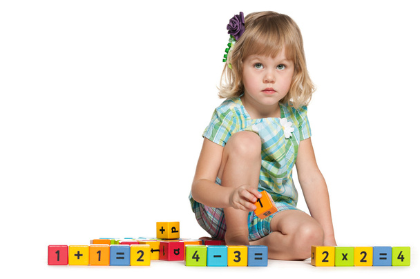 Задумчивая маленькая девочка с блоками
 - Фото, изображение