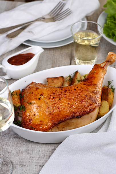 Roasted turkey leg with potatoes on the dinner table - Foto, Imagen