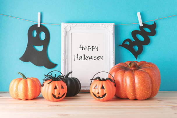 Holiday concept with Halloween pumpkin decor and photo frame on wooden table. Creative Halloween minimal concept. - Фото, изображение