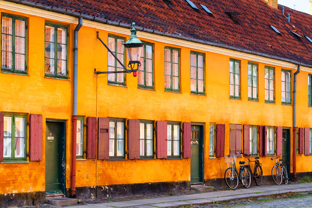 KOPENHAGEN, DÄNEMARK - 8. OKTOBER 2016: Schöne alte gelbe Häuser in Nyboder, dem mittelalterlichen Viertel von Kopenhagen, Dänemark. Retro-Fahrrad geparkt vor dem Gebäude auf dem Bürgersteig. - Foto, Bild