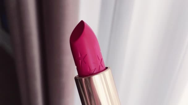 Różowa szminka w złotej tubie jako luksusowy produkt kosmetyczny, makijaż i uroda - Materiał filmowy, wideo