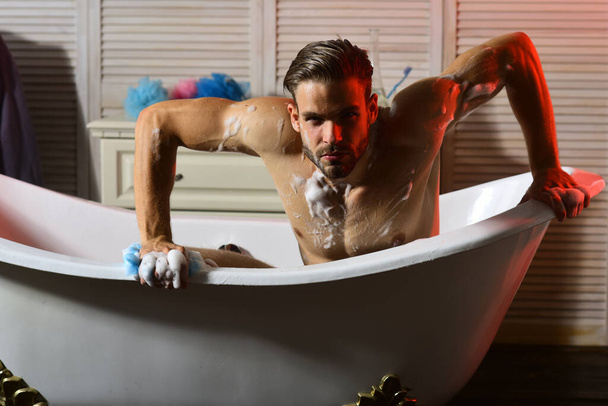 Macho in bathtub like hunting beast, selective focus - Фото, изображение