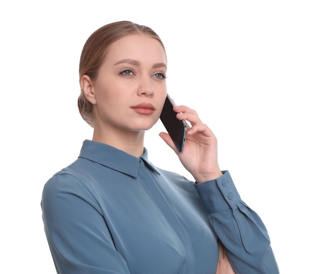 Young businesswoman talking on mobile phone against white background - Foto, imagen