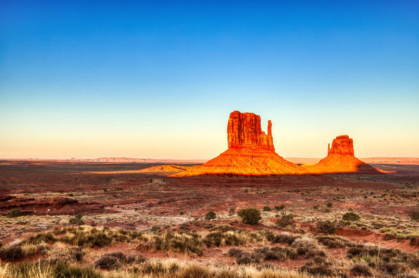 アメリカ、ユタ州とアリゾナ州の境界、サンセットに照らされたナバホ国立公園の記念碑の谷   - 写真・画像