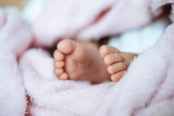 Bebé recién nacido pies en una manta blanca. - Foto, imagen