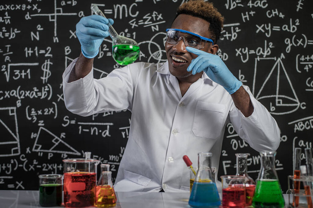 Gli scienziati hanno puntato le mani e guardato le sostanze chimiche verdi nel vetro al laboratorio.. - Foto, immagini