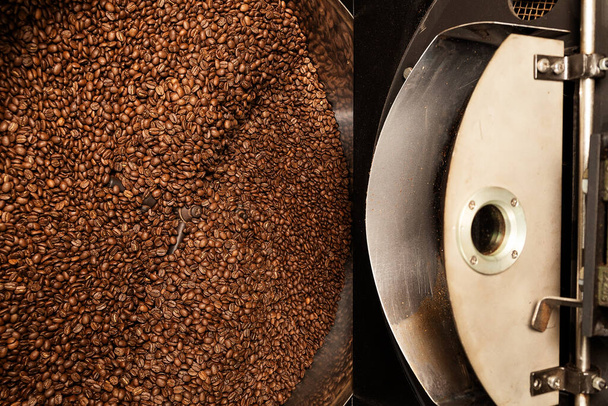 Grãos de café naturais torrados frescos que cascata fora da máquina industrial do torrador do feijão de café dentro da cafetaria
 - Foto, Imagem