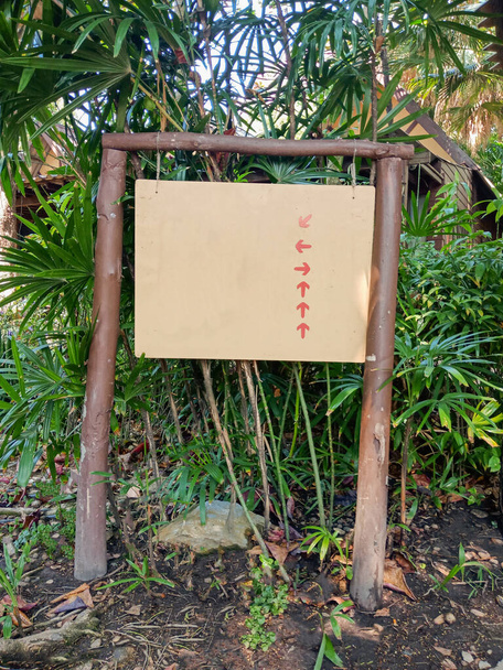 Lege banner wegwijzer met pijl in groene tuin resort - Foto, afbeelding