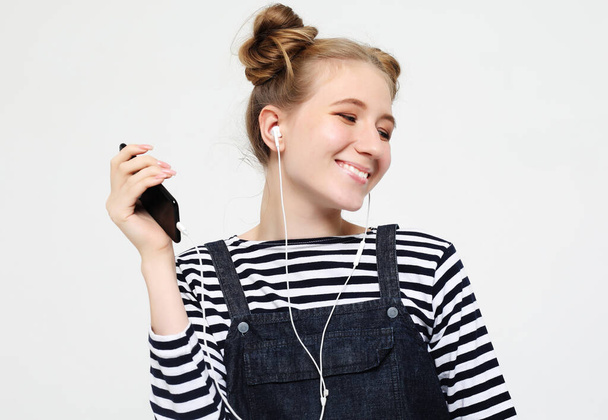 Beautiful woman in headphones listening to music on white background - Valokuva, kuva