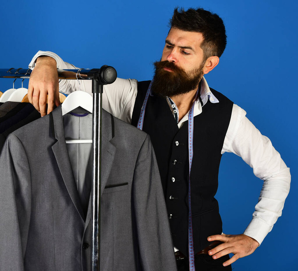 Man with beard by clothes rack. Fashion and individual style - Φωτογραφία, εικόνα