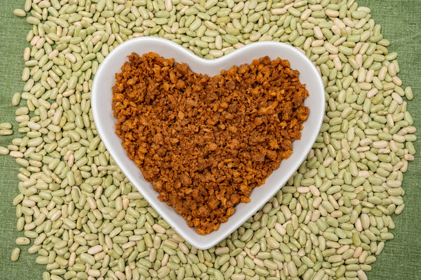 Love vegan and vegetarian food concept, plant based minced meat in heart shaped plate on soya beans background close up - Photo, Image