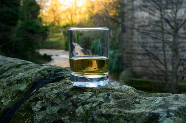 Scotch single malts or blended whisky spirits in glasses with water of river Spey on background, Σκωτία, Ηνωμένο Βασίλειο - Φωτογραφία, εικόνα