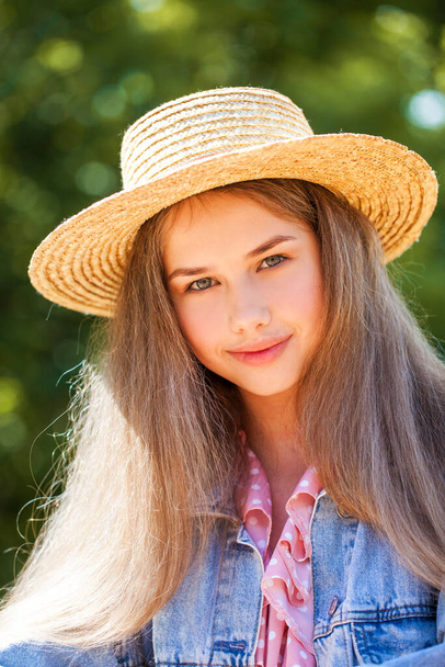 Portrait of a young girl in a straw hat - Foto, afbeelding